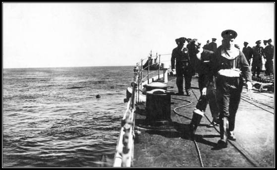Crew members releasing mine (seen bobbing, center)
From bottom of ship. (H.M.S. Birmingham)
